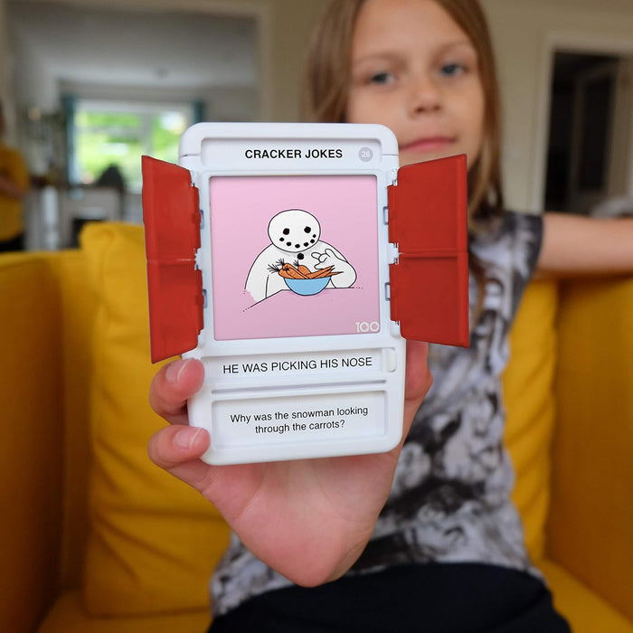 Child holding a white handheld game with red doors open, featuring a snowman cartoon and a Christmas riddle.