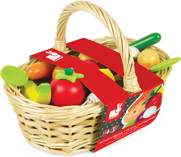 Woven wicker basket with colorful wooden toy produce, featuring a red Janod brand sleeve and a large handle.