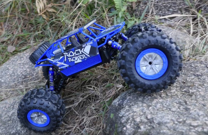 Red and black 2.4G 4WD amphibious RC crawler buggy from dealonline.co.nz, shown driving on rugged terrain.