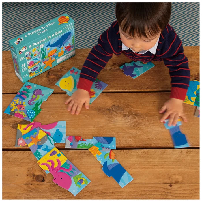 Child playing with colorful sea creature puzzle pieces on a wooden table next to a blue ocean-themed product box.