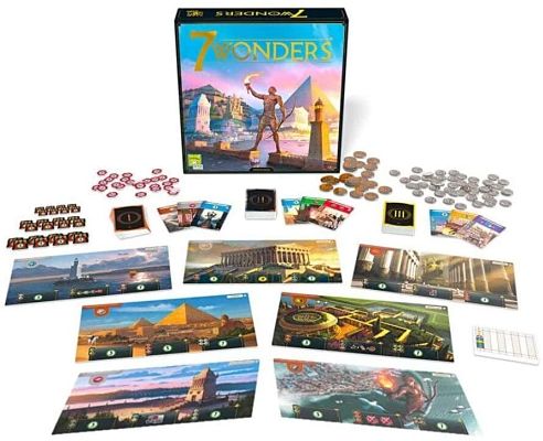 7 Wonders board game box featuring ancient landmarks above colorful boards, cards, and coins on a white surface.