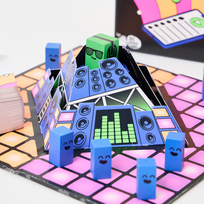 Music board game featuring a 3D speaker booth, neon grid board, blue smiley pieces, and a green DJ block.