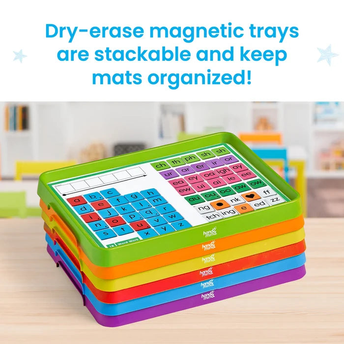 Six colorful stacked plastic trays; top tray shows a phonics mat with magnetic letter and phoneme tiles.