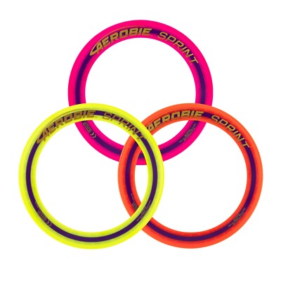 Three circular disc golf discs overlapping on a white background, each with a neon outer ring and a darker inner ring. The top disc is bright pink, the left disc is bright yellow, and the right disc is bright orange, with black and yellow 'CEROBIE GODPINT' branding printed on them.