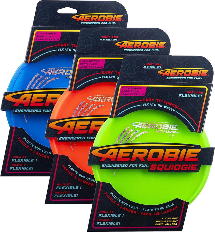 Three flexible flying discs in blue, orange, and neon green, displayed in dark blue hanging retail packages.
