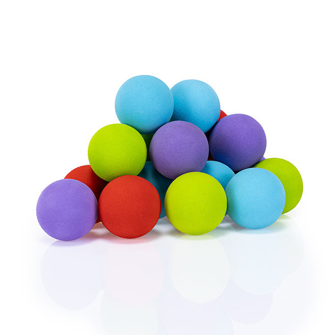 A pile of colorful foam balls in red, blue, purple, and green on a reflective white surface.