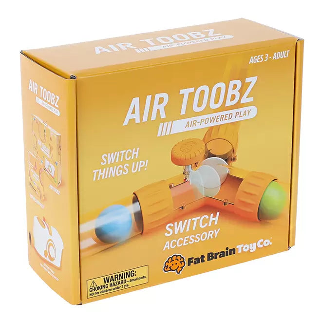Yellow box showing a clear T-shaped tube with orange connectors and a top dial used to divert colorful balls.