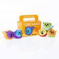 Five colorful round plush animals with whiskers and ears displayed next to their yellow and orange product box.