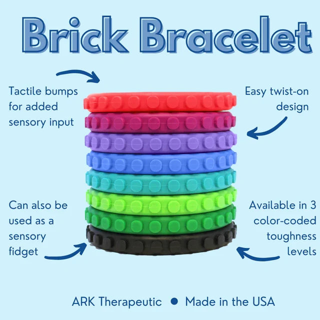 Stack of nine silicone bracelets in a variety of colors with raised brick-style bumps for tactile sensory input.