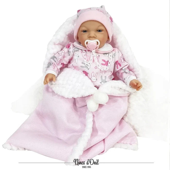 Realistic baby doll in pink bunny onesie and hat, wrapped in a pink and white fuzzy blanket with a pacifier.