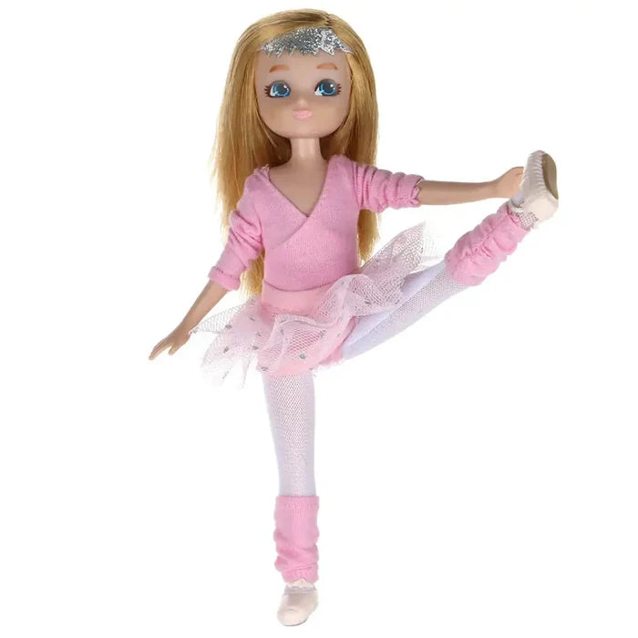 Blonde doll in a pink ballet wrap top, tutu, and leg warmers, holding one leg up in a dance pose.