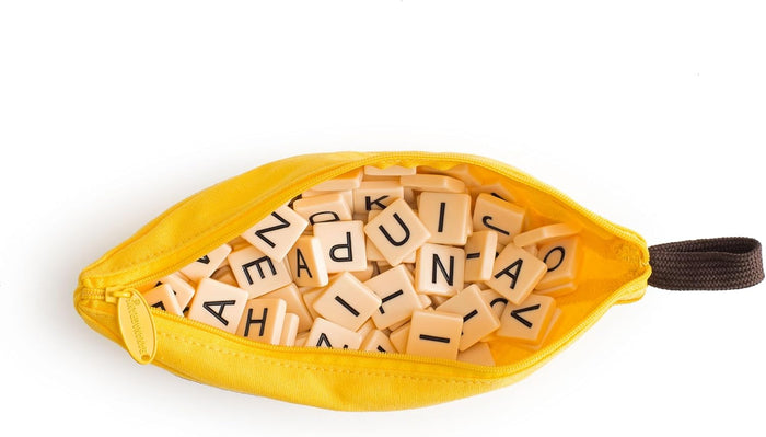 Open yellow banana-shaped zipper pouch filled with cream-colored square letter tiles.