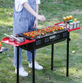 Portable folding barbecue charcoal grill for camping and picnics, with a compact design and handles for easy transport.