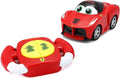 Red cartoon Ferrari toy with large green eyes and a matching steering wheel remote with yellow buttons.