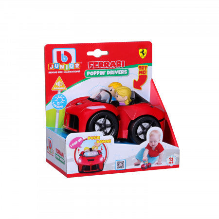 Red toy Ferrari with two driver figures in colorful packaging showing light, sound, and pop-up action features.