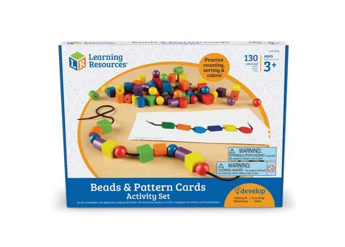 Box of colorful wooden beads in various shapes including spheres and cubes with a lacing string and pattern card.