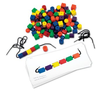 Colorful wooden spheres, cubes, and cylinders with black laces and pattern cards for a bead-stringing set.