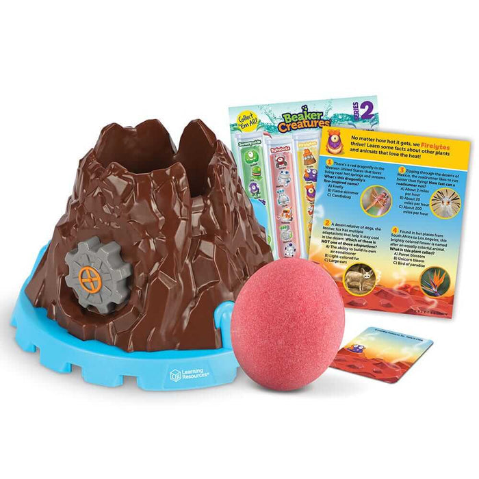 Brown toy volcano with grey gear dial on blue base, a textured pink sphere, and colorful educational cards.
