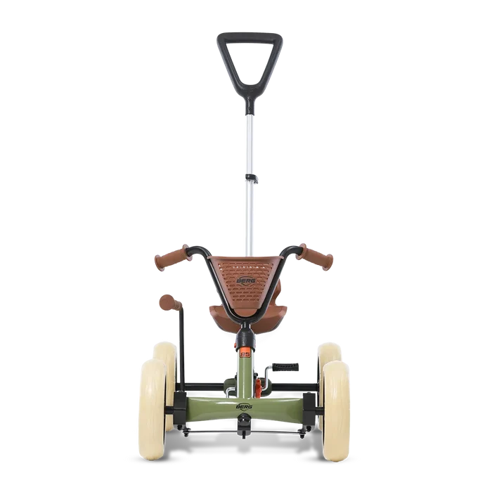 Green pedal go-kart with four cream wheels, brown seat and basket, and a tall adjustable push bar.