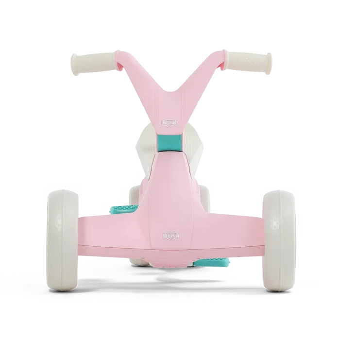 Rear view of a pink and white ride-on toy with wide wheels, teal accents, and Y-shaped handlebars.