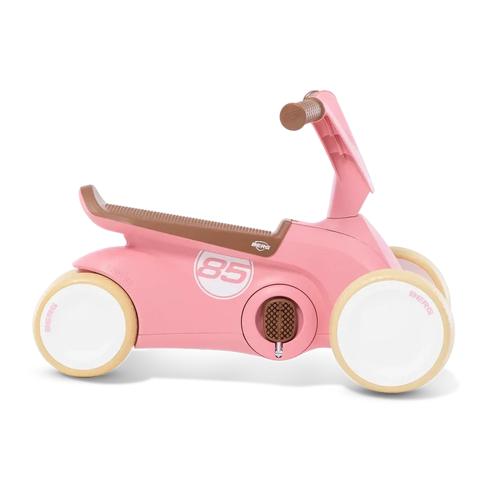 Pink four-wheeled toddler ride-on toy with brown seat, cream tires, and a white number 85 on the side.