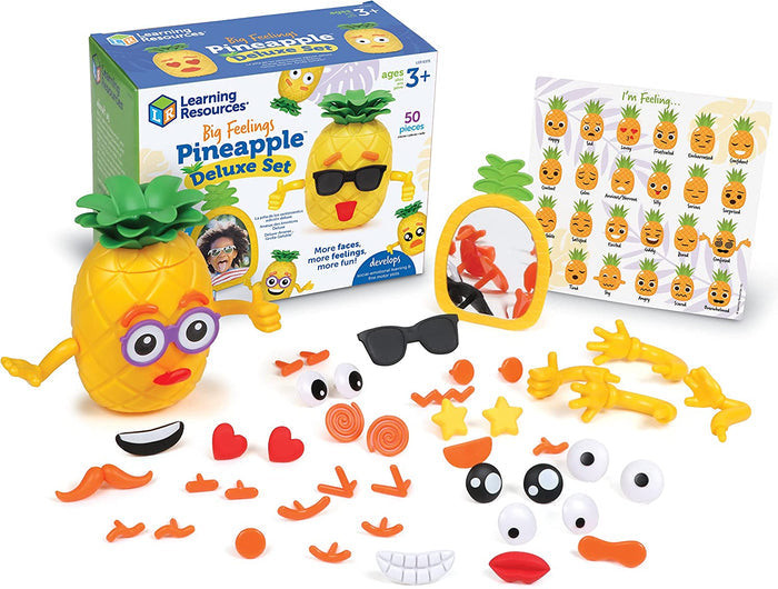 Yellow pineapple toy with interchangeable facial features, a mirror, and emotion chart next to its colorful packaging.