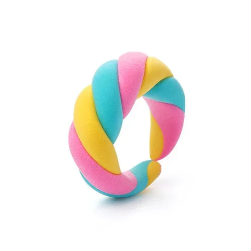 Twisted pink, yellow, and blue ring toy with a soft, marshmallow-like texture against a white background.
