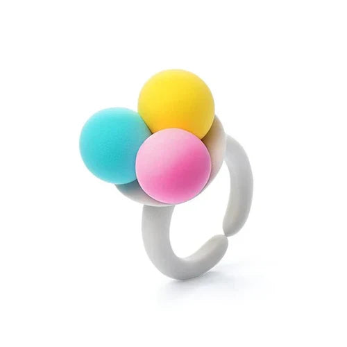 White chunky ring topped with three matte spheres in bright cyan, yellow, and pink.