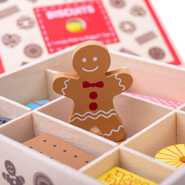 Wooden toy gingerbread man with red bow tie in a partitioned wooden box with colourful play food biscuits.