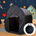 Black pop-up sensory dome tent with an arched entrance and circular carry bag in a space-themed child's bedroom.