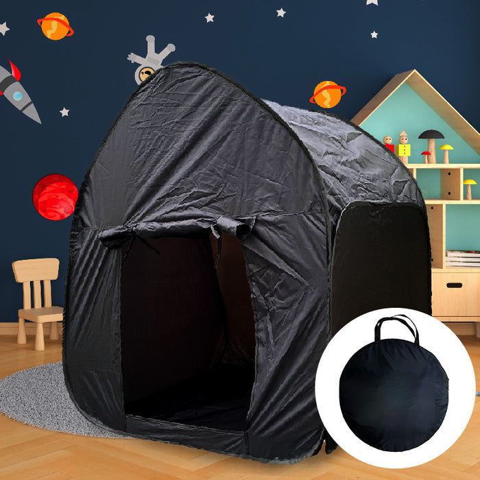Black pop-up sensory dome tent with an arched entrance and circular carry bag in a space-themed child's bedroom.