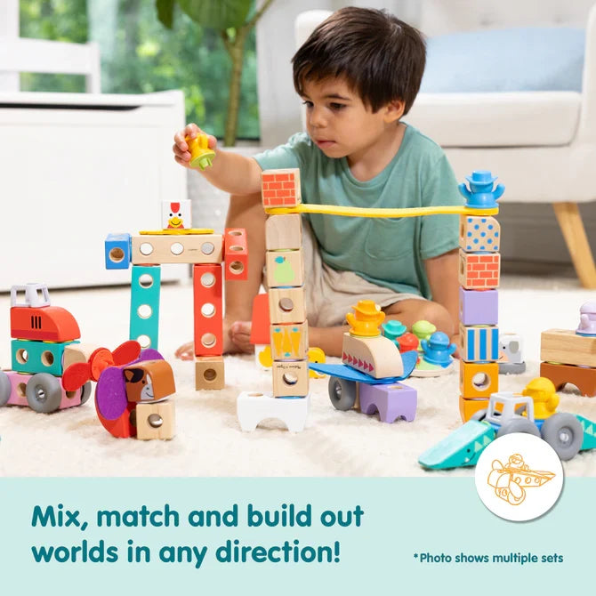 A child builds colorful toy vehicles and structures with patterned wooden peg-and-hole blocks.