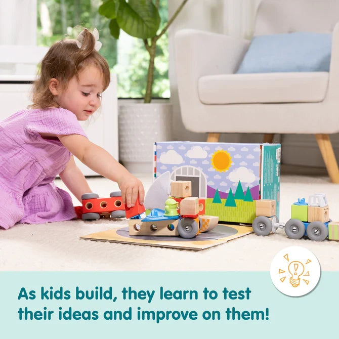 Toddler playing with colorful wooden and plastic vehicle blocks on a rug, next to a sun-illustrated box.