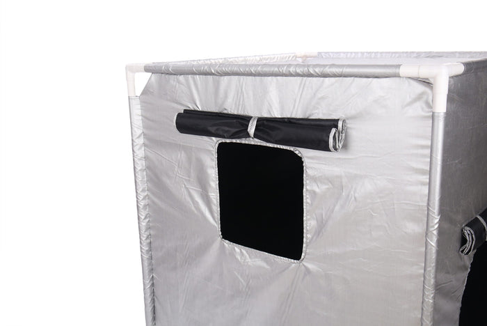 Silver cube-shaped tent with a white plastic frame and a black square window with a rolled-up fabric cover.