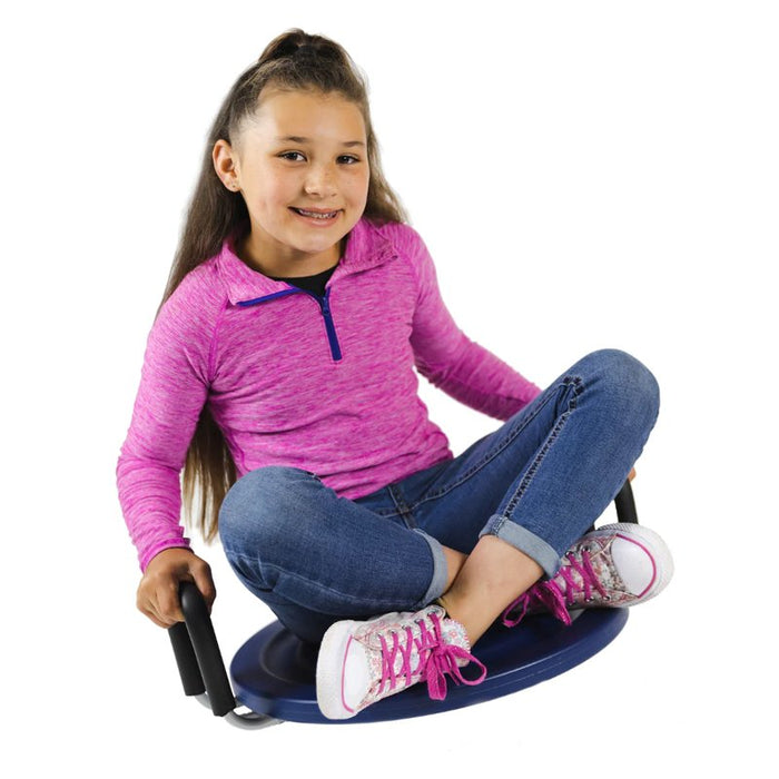 Girl sitting cross-legged on a blue circular rocking disc with black handles.