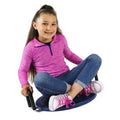 Girl sitting cross-legged on a blue circular rocking disc with black handles.