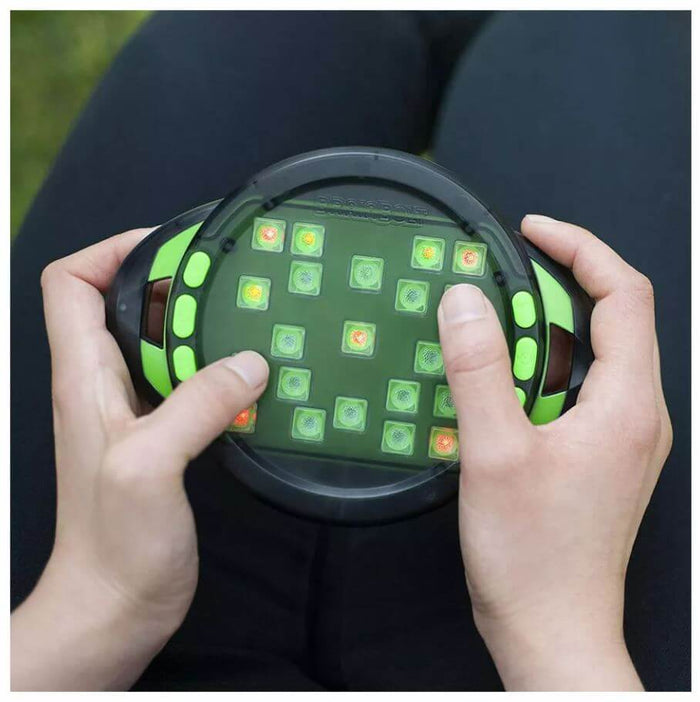 Hands holding a round black and neon green handheld electronic game with small, multicolored glowing square buttons.
