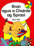 Yellow puppy in a toy box with colorful toys like a train and ball on a red children's book cover with Irish text.