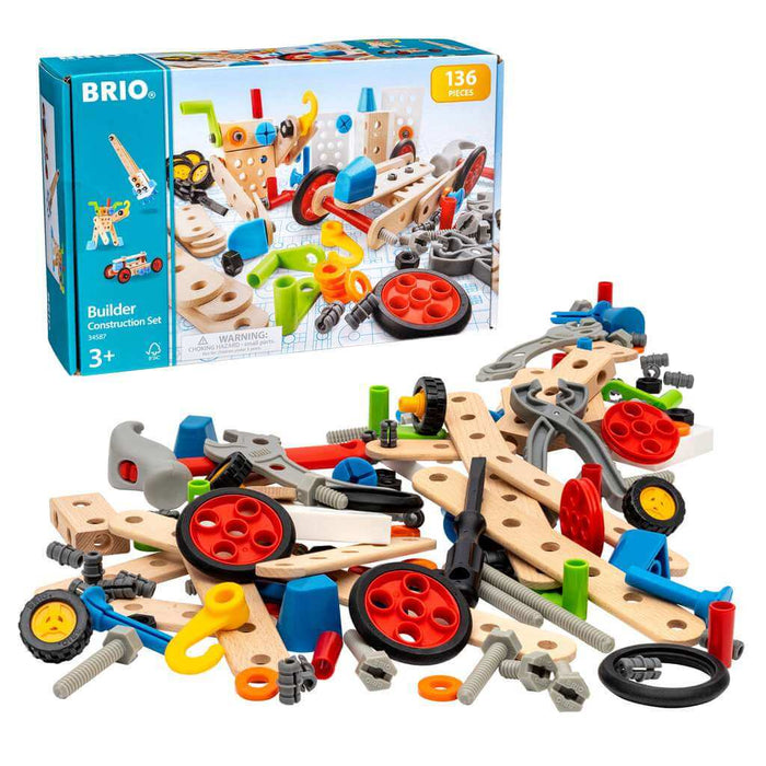 Building toy box behind a pile of natural wood slats, colorful plastic screws, red wheels, and grey hand tools.