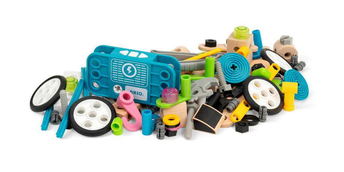 Assorted building parts including a teal motor, white wheels, wooden blocks, and colorful bolts in a pile.