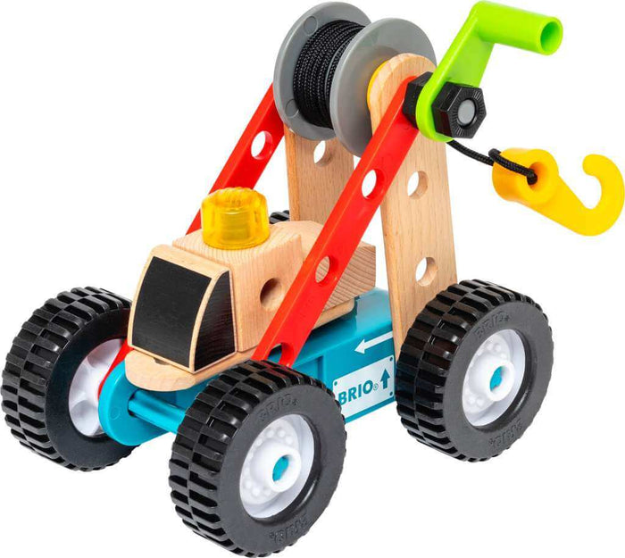 Colorful wooden toy crane with red plastic beams, a blue base, large black wheels, and a yellow hook on a winch.