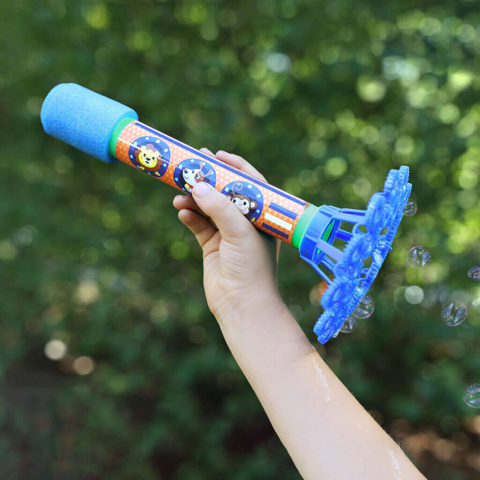 Child holding a colorful bubble wand with animal faces and a blue foam handle, emitting bubbles against green foliage.
