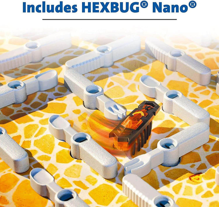 Orange Hexbug Nano robot moving through a maze of rotating silver plastic cutlery on a yellow patterned game board.