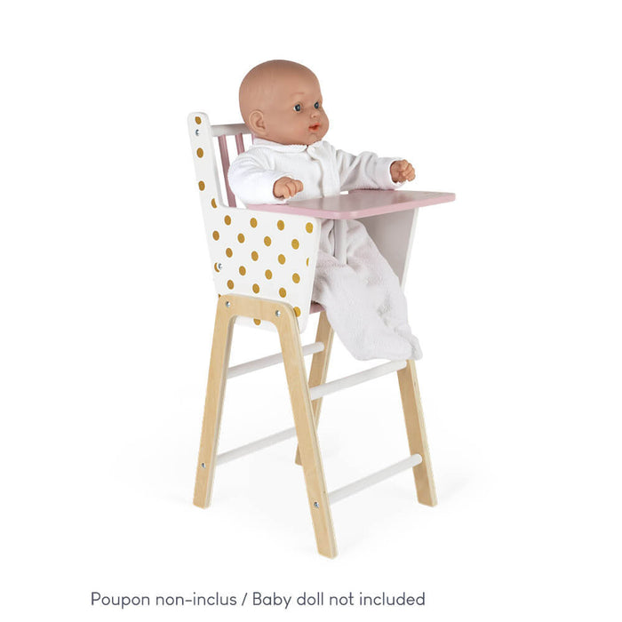 Toy high chair with gold polka dot sides, pink tray, and natural wood legs.