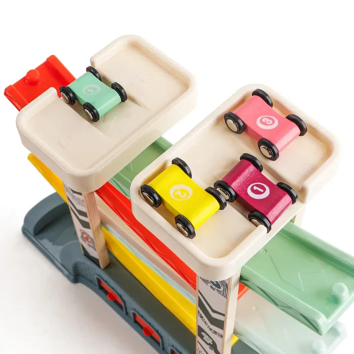 Multi-level toy ramp with four numbered wooden cars in green, yellow, pink, and red on top platforms.