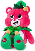Pink plush bear wearing a green elf hat, scalloped collar, and elf shoes with yellow pom-poms and a bow.