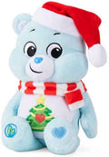 Light blue plush Care Bear wearing a red Santa hat, striped scarf, and an embroidered Christmas tree on its belly.