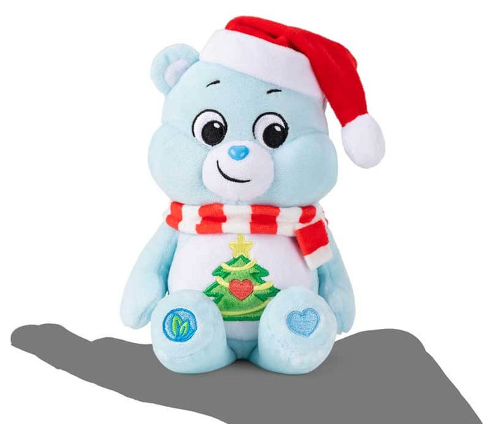 Light blue plush bear wearing a red Santa hat and striped scarf with a Christmas tree and heart belly badge.