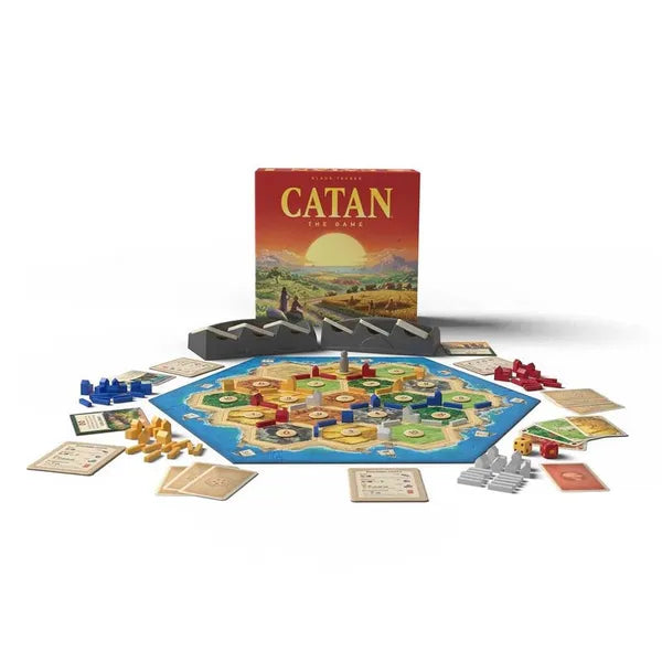 Red game box behind a set-up hexagonal board with colorful resource tiles, player pieces, cards, and dice.