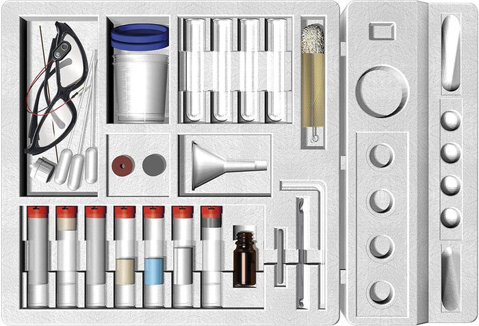 Chemistry set in a white foam tray with safety goggles, test tubes, a funnel, and small vials with red caps.